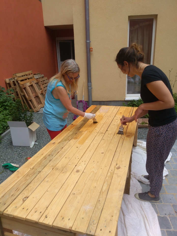 Deux femmes retapent une table de jardin 